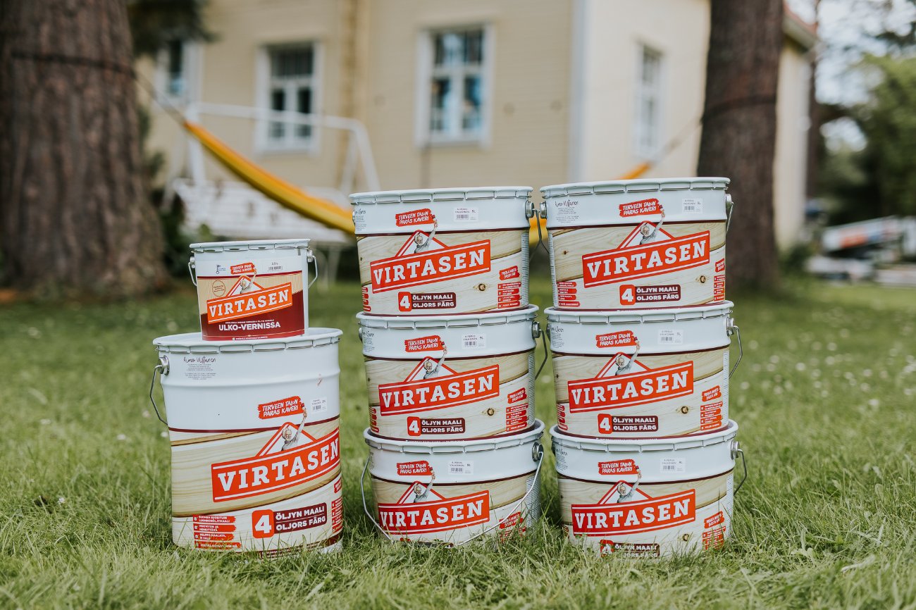 Virtasen Maalitehtaan maalipurkkeja nurmikolla.